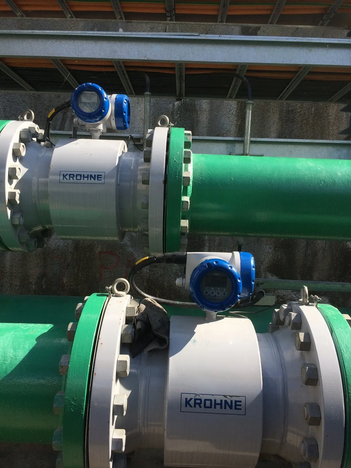 Two Krohne electromagnetic flowmeters installed on flanged green pipelines at a mine dewatering station