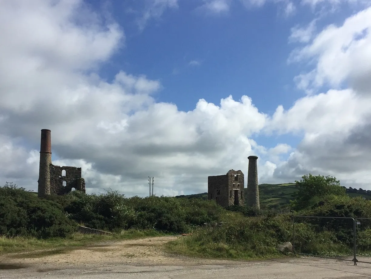 Ruined Cornish engine houses and chimney stacks amid gorse at the South Crofty mining site near Pool