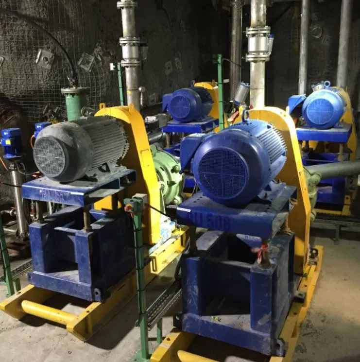 Row of underground mine dewatering pumps with large blue electric motors on steel skids