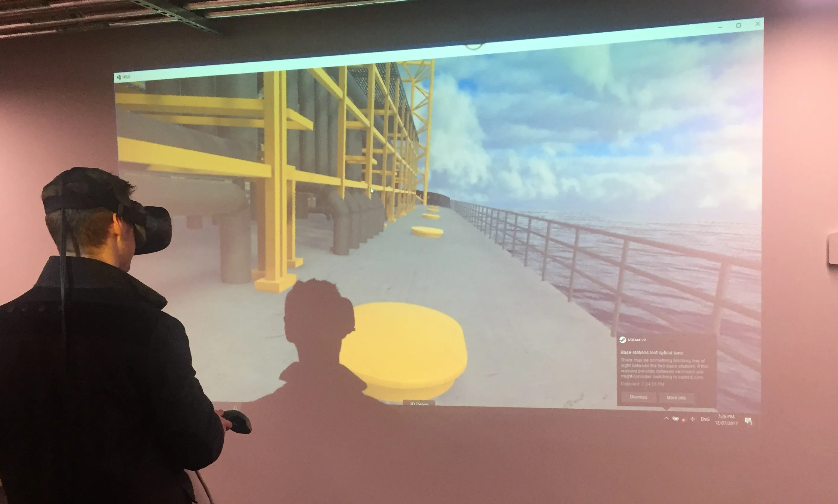 Person wearing a VR headset views a projected 3D walkway model of an offshore platform structure
